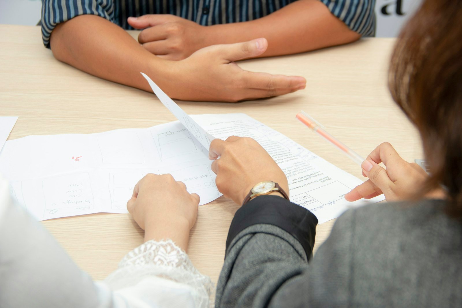 Two people reviewing documents at a meeting table