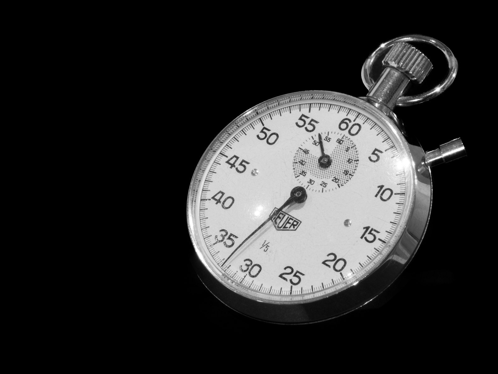 Stopwatch ticking on a dark surface