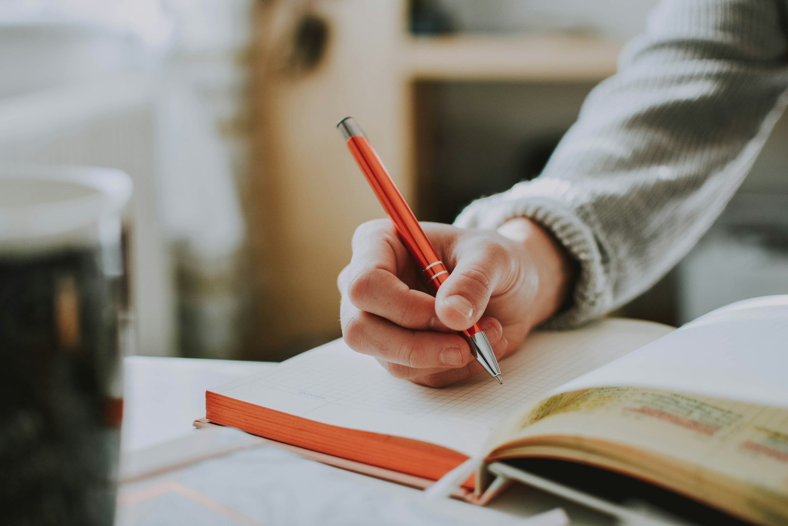 Writer drafting content with a red pen and notebook